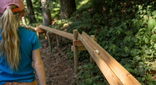 Abbildung von einem Kind bei einer Waldkugelbahn